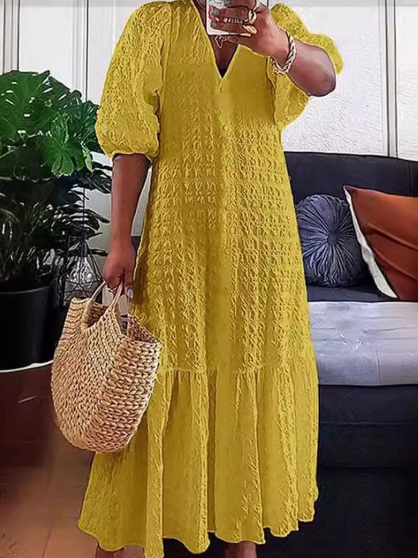 Yellow textured maxi dress with V-neck, puff sleeves, and flowing tiered skirt