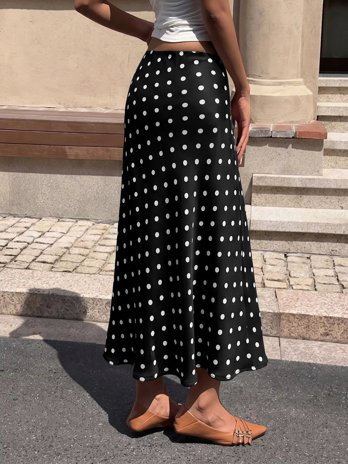 Black midi skirt with white polka dots and wide flared hem