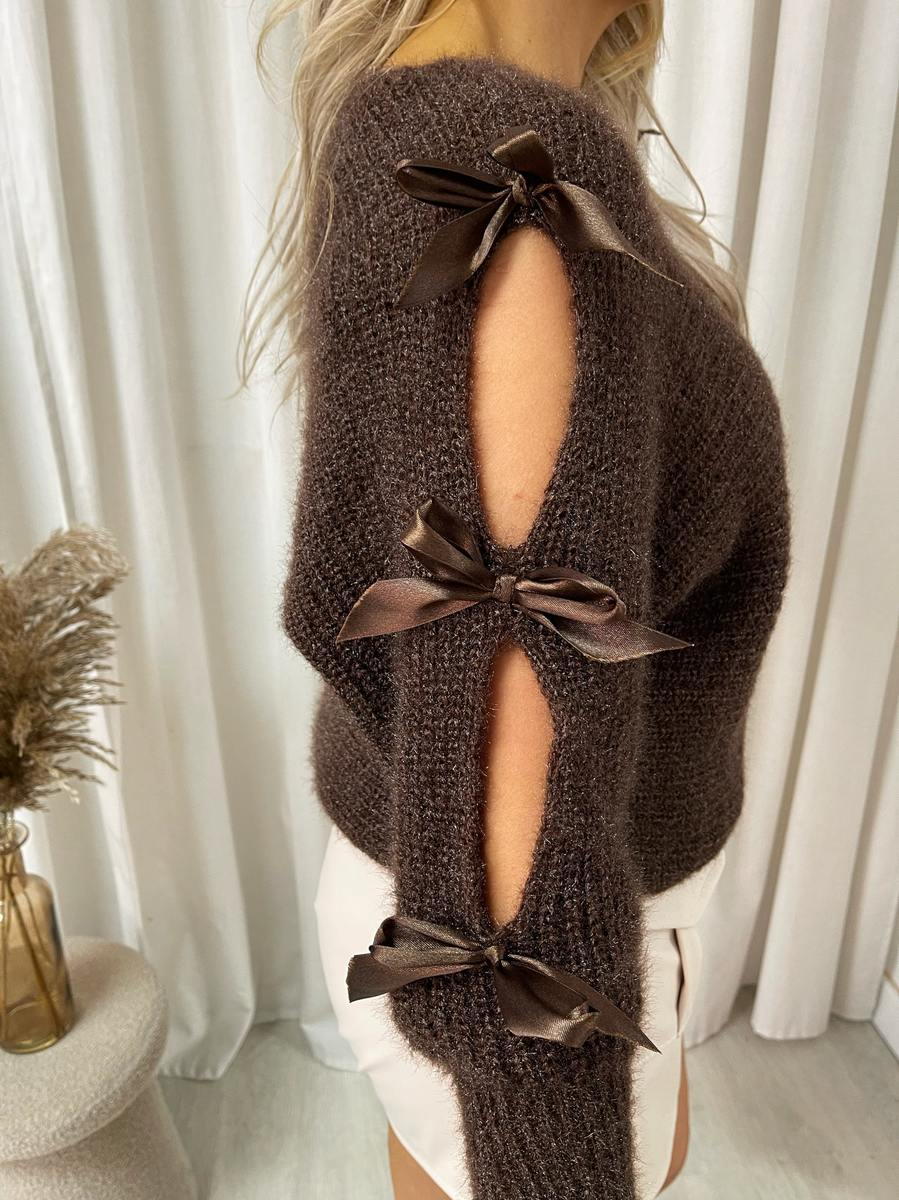 "Chunky knitted top with cut-out tie bow sleeve detail in beige, perfect for cozy winter wear."