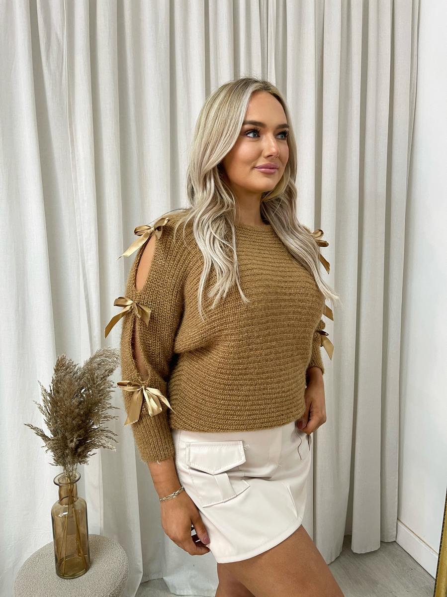 "Chunky knitted top with cut-out tie bow sleeve detail in beige, perfect for cozy winter wear."