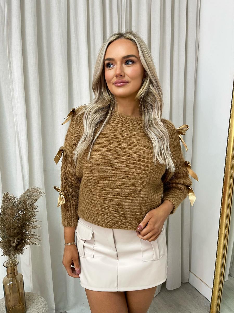 "Chunky knitted top with cut-out tie bow sleeve detail in beige, perfect for cozy winter wear."
