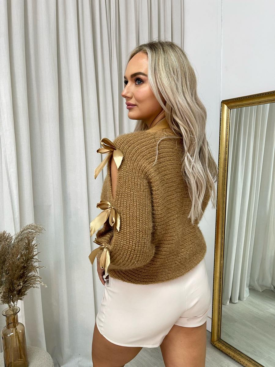 "Chunky knitted top with cut-out tie bow sleeve detail in beige, perfect for cozy winter wear."