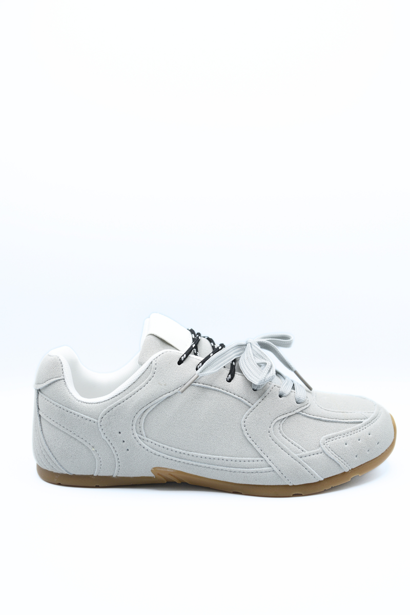 White lace-up flat trainers with black laces and beige rubber sole