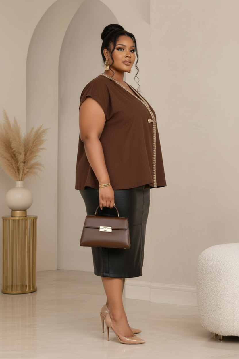 Side view of a chocolate-brown embellished blouse styled with a black leather midi skirt