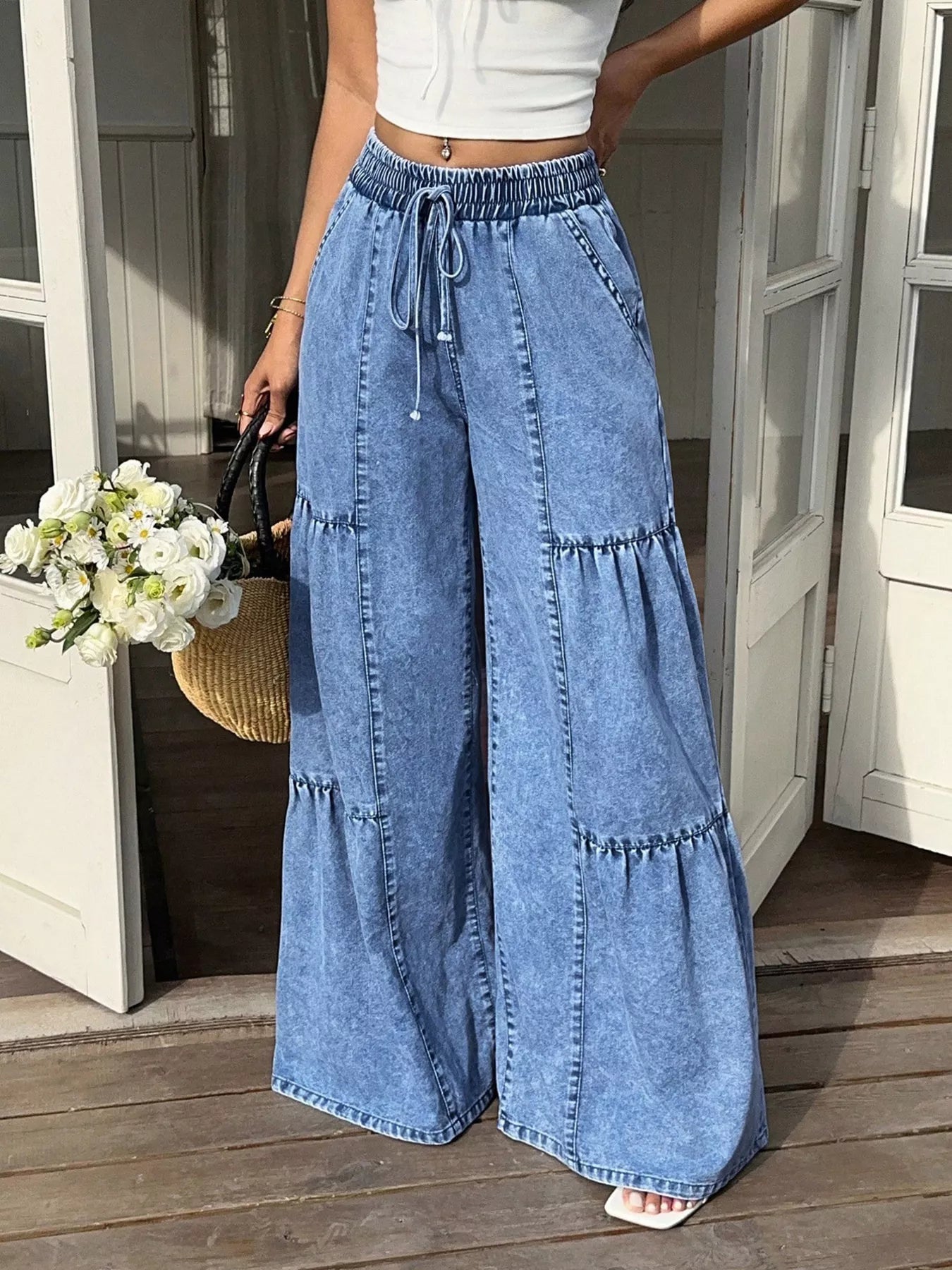 Blue denim wide-leg tiered jeans with drawstring elastic waist and tiered panels