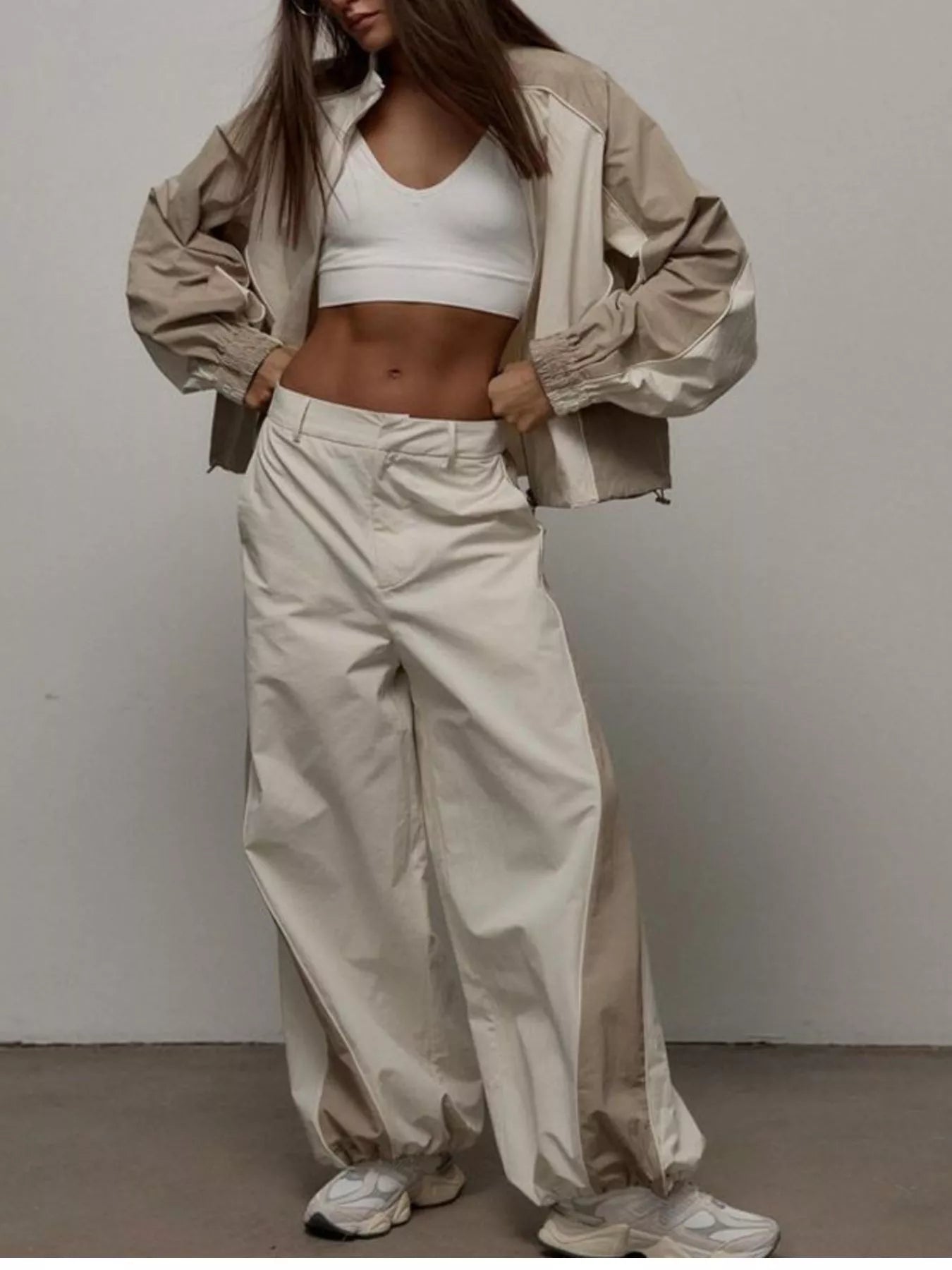 Two-piece zip-up jacket and wide-leg pants set in light beige/cream, color-block styling.