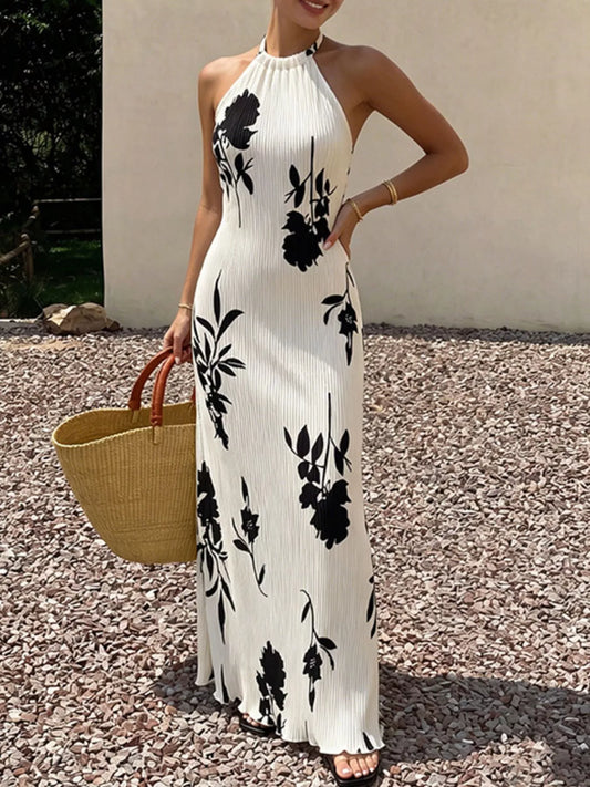 White halter neck maxi dress with black floral print, sleeveless fitted bodice