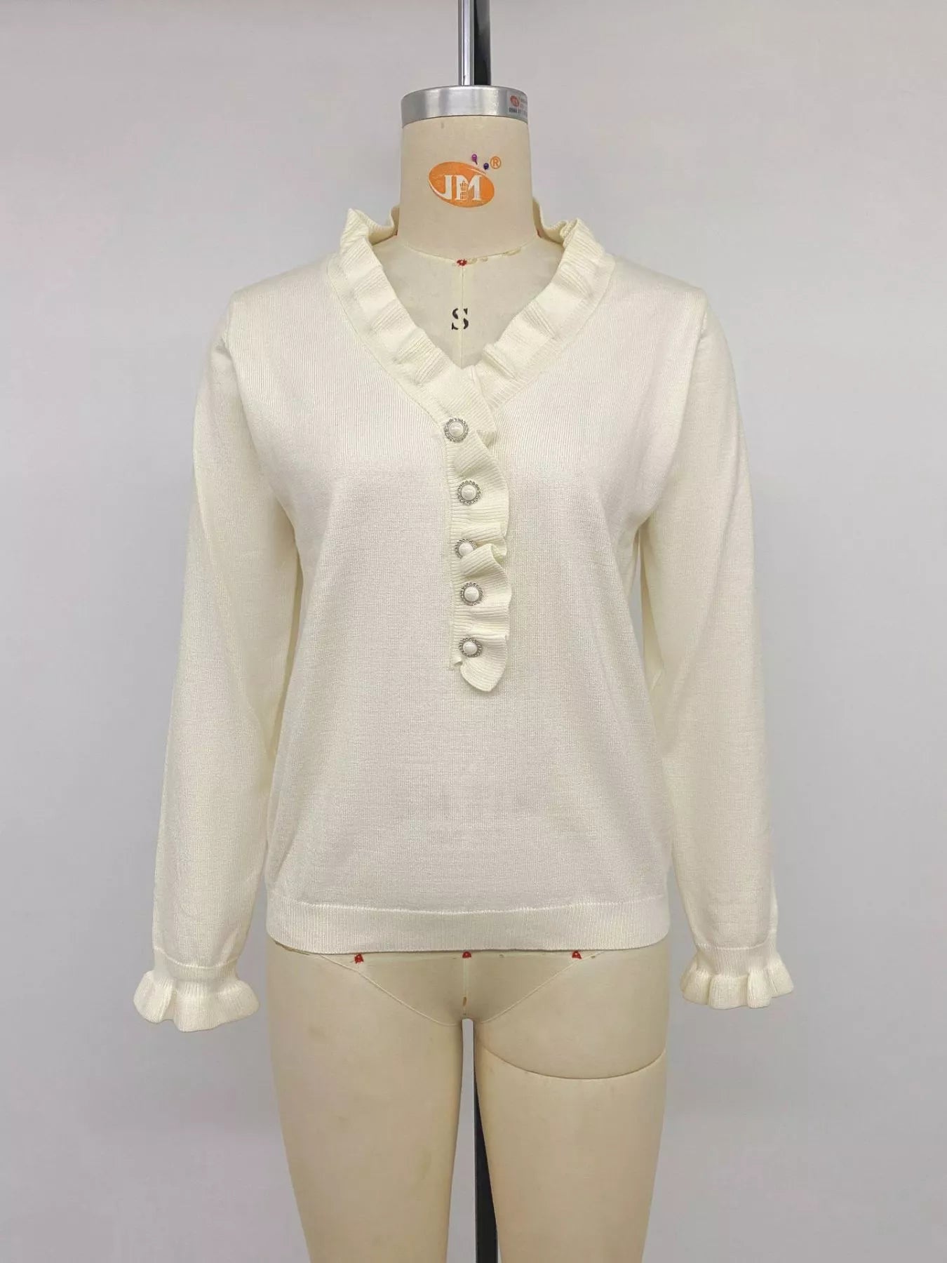 Apricot ruffle V-neck knit top with pearl buttons and long sleeves