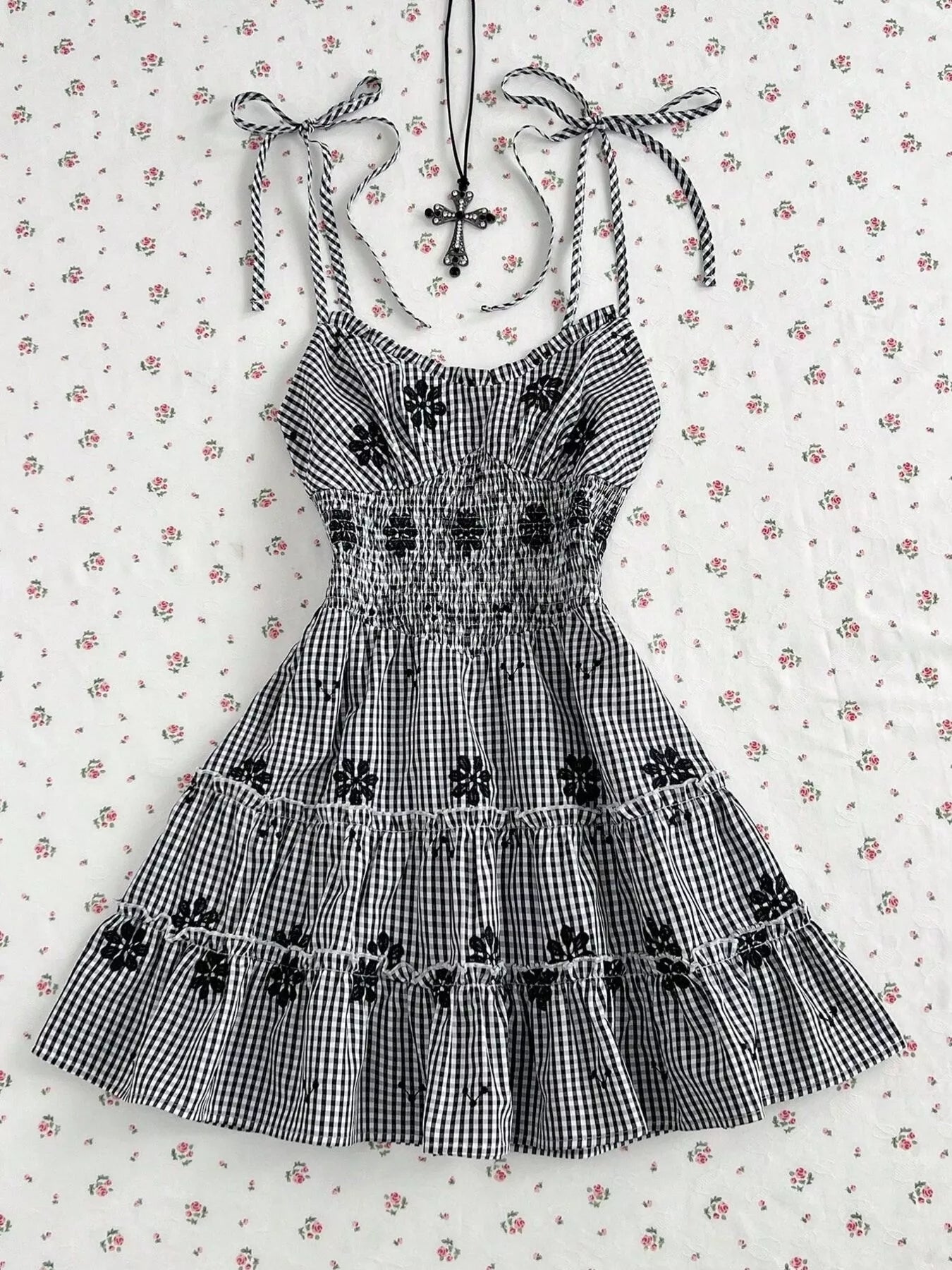 Black gingham floral tiered mini dress with spaghetti straps and gathered ruffle skirt