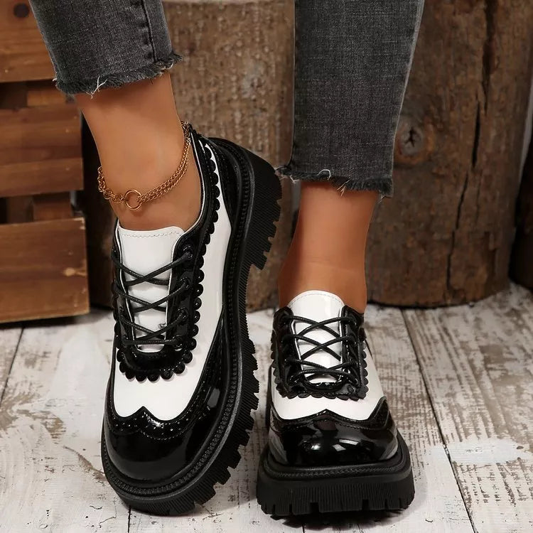 White and black platform loafers with lace-up detail and round toe, thick sole