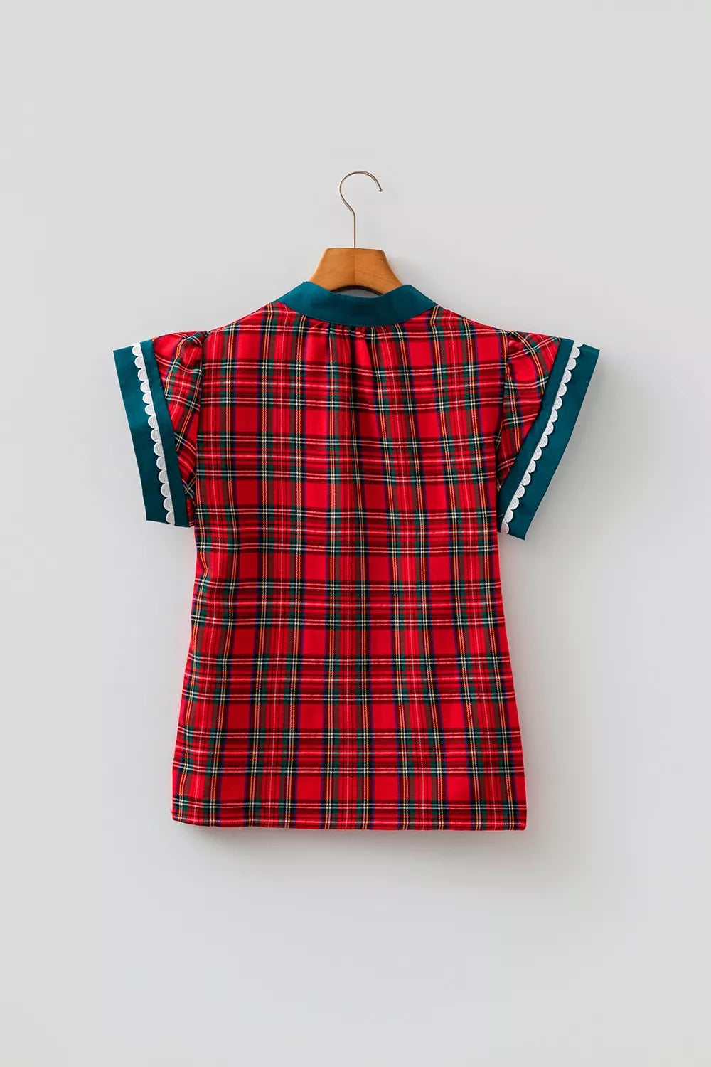 Back view of deep red plaid V-neck shift blouse with teal scalloped sleeve trim