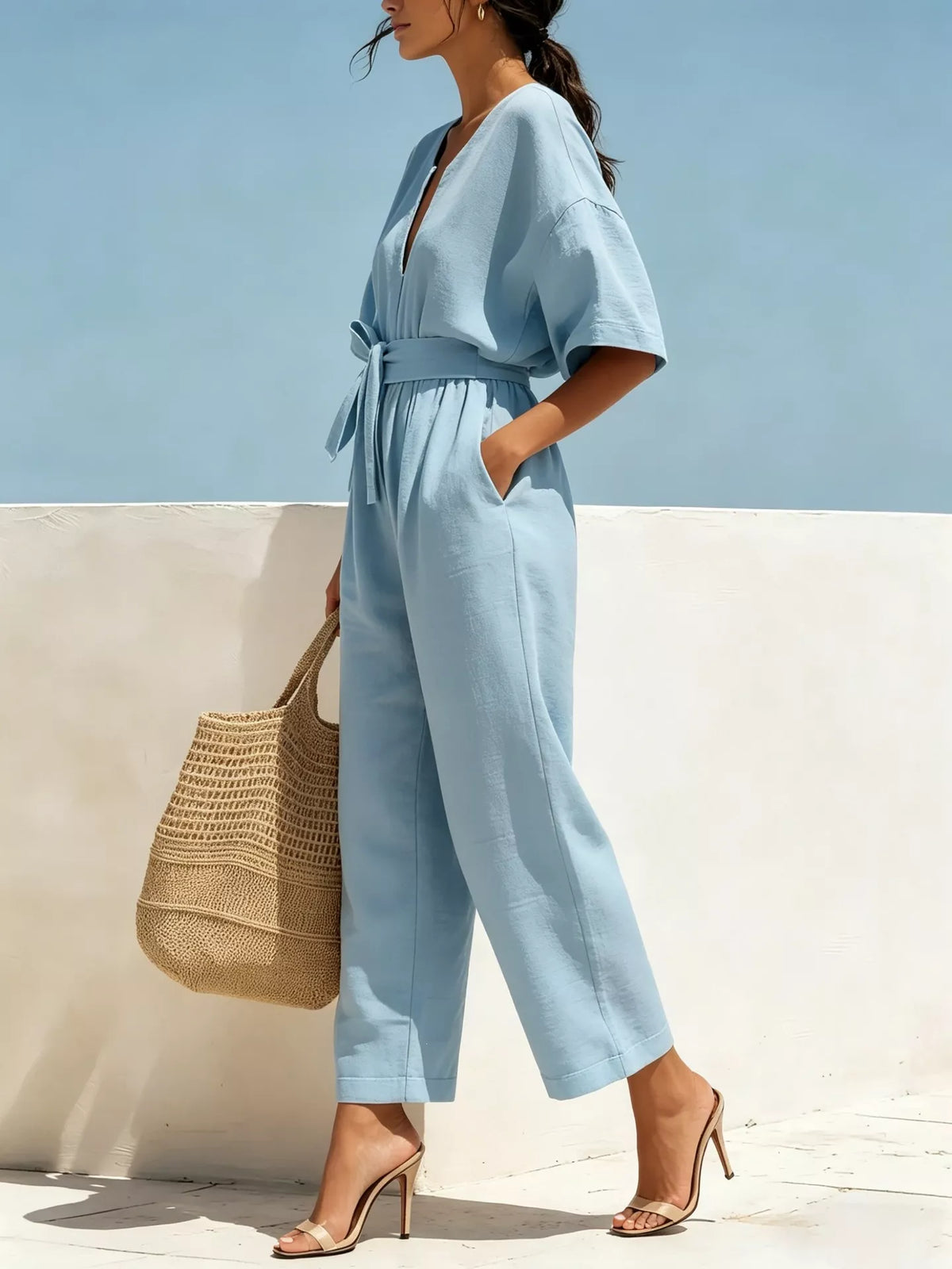 Sky blue tie-waist wide-leg jumpsuit with V-neck, short sleeves, and draped front