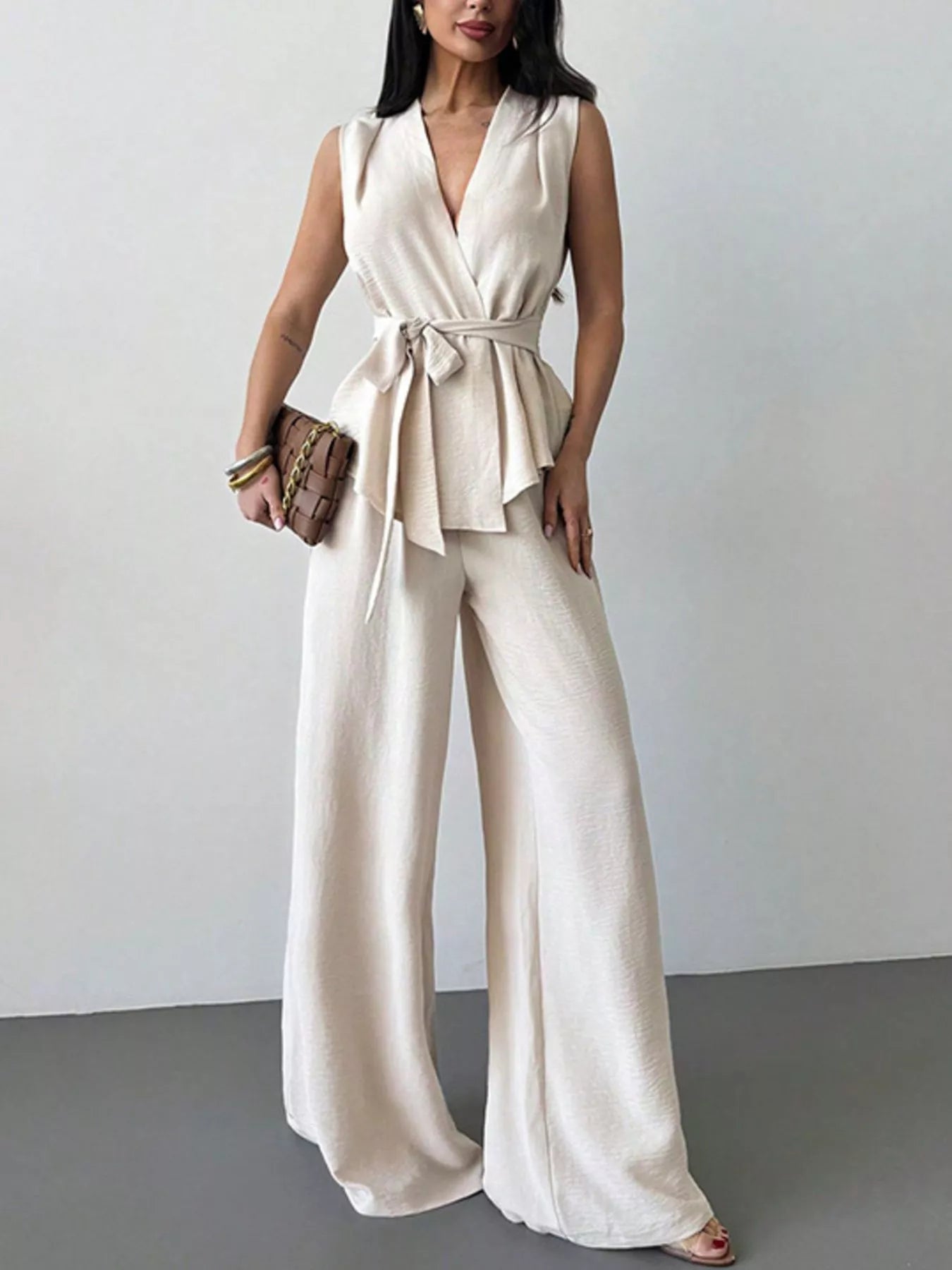 White sleeveless wrap top and wide-leg pants set, belted waist and flowing wide legs