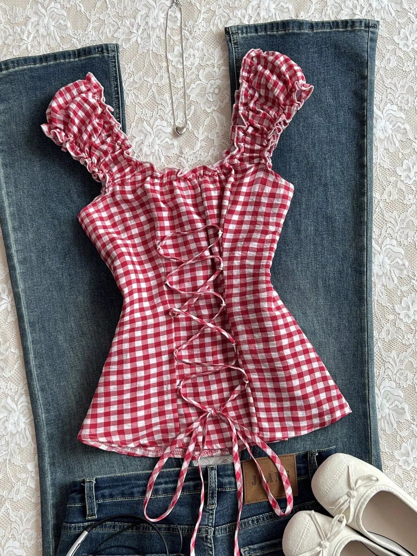Red gingham blouse with frill cap sleeves, button placket, and lace-up front