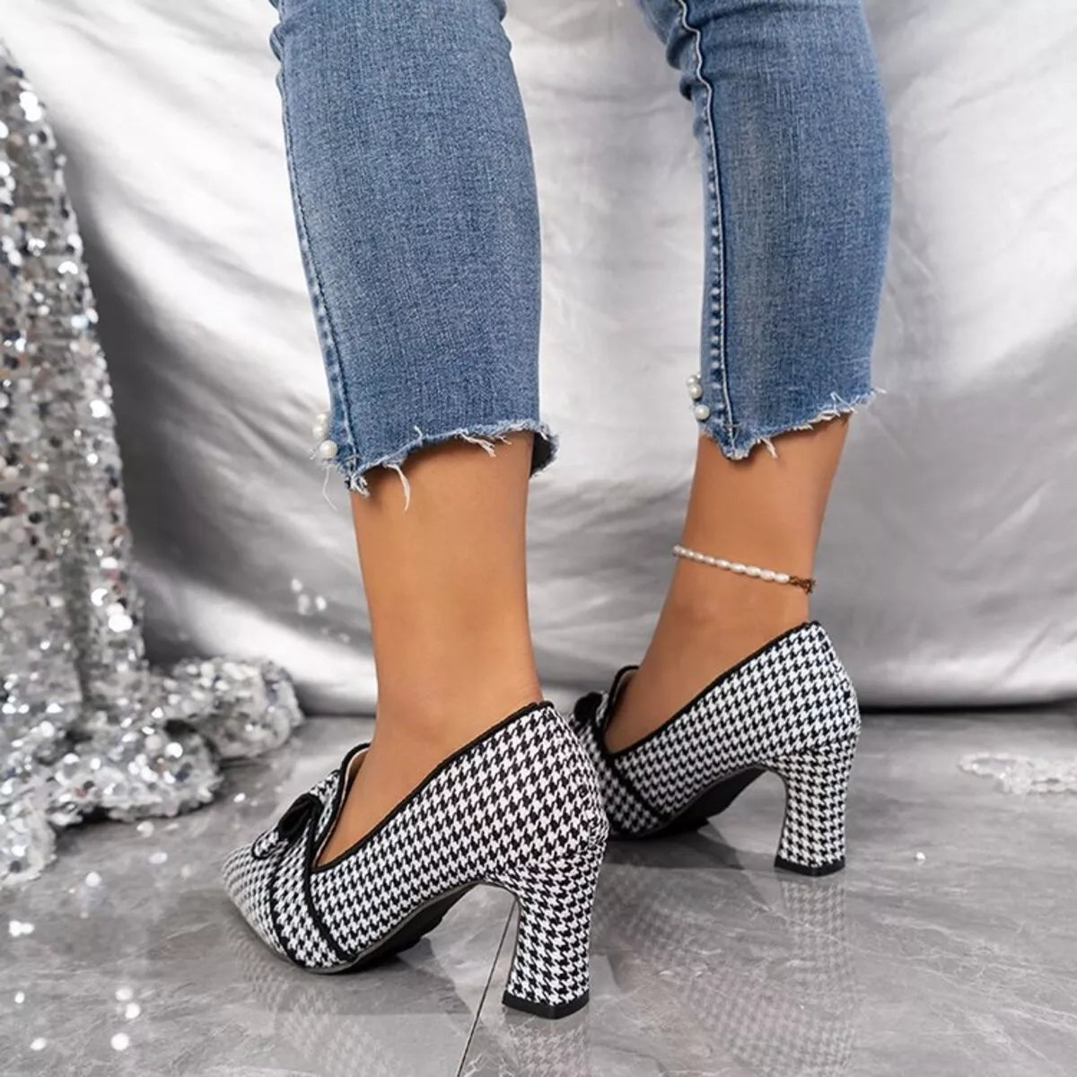 Point-toe block heel pumps in black-and-white houndstooth, rear angle with block heel