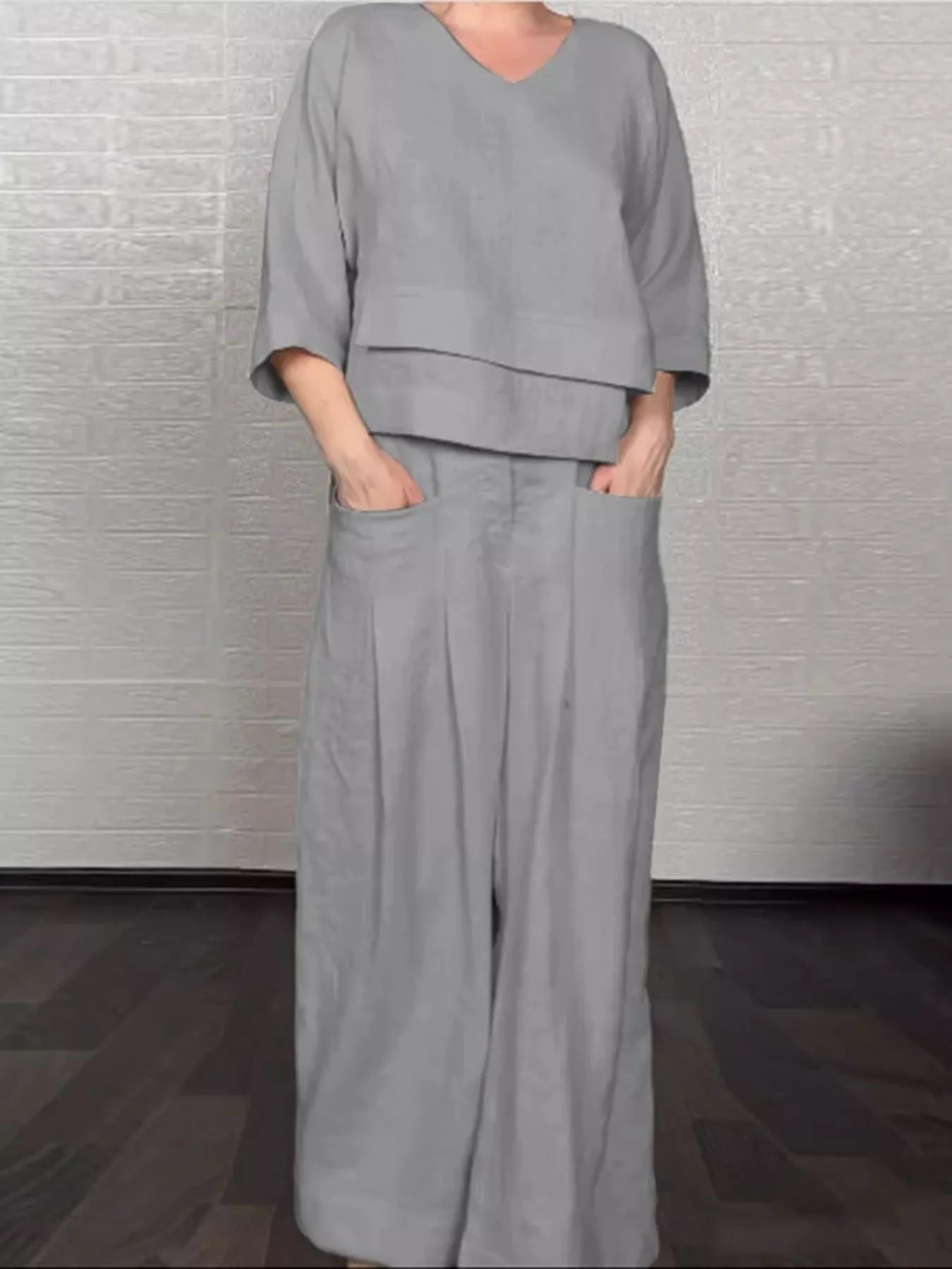 Grey V-neck long sleeve top and wide-leg pants set, relaxed fit with layered hem.