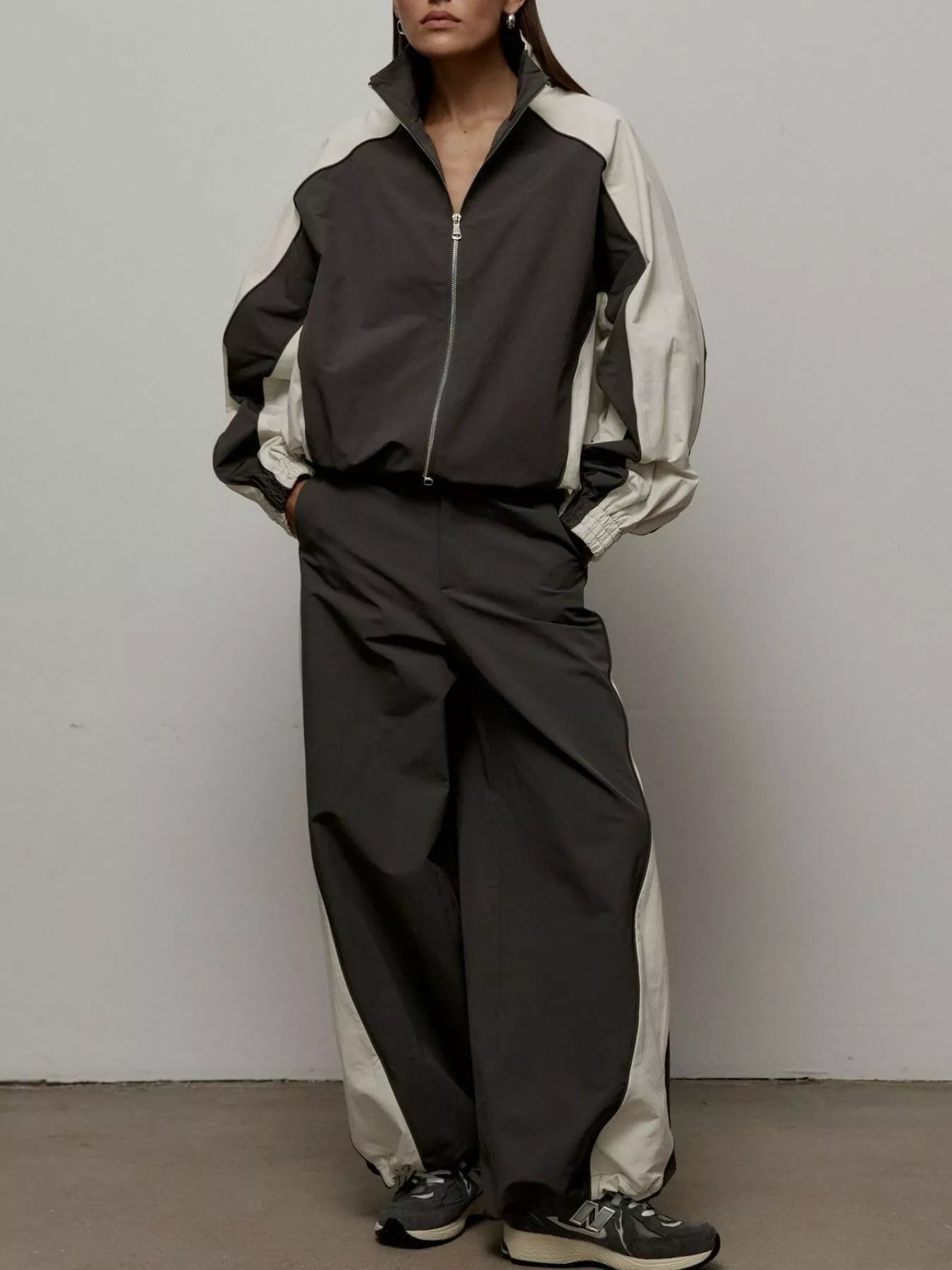 Color-block zip-up jacket and matching wide-leg pants set, black with light panels.