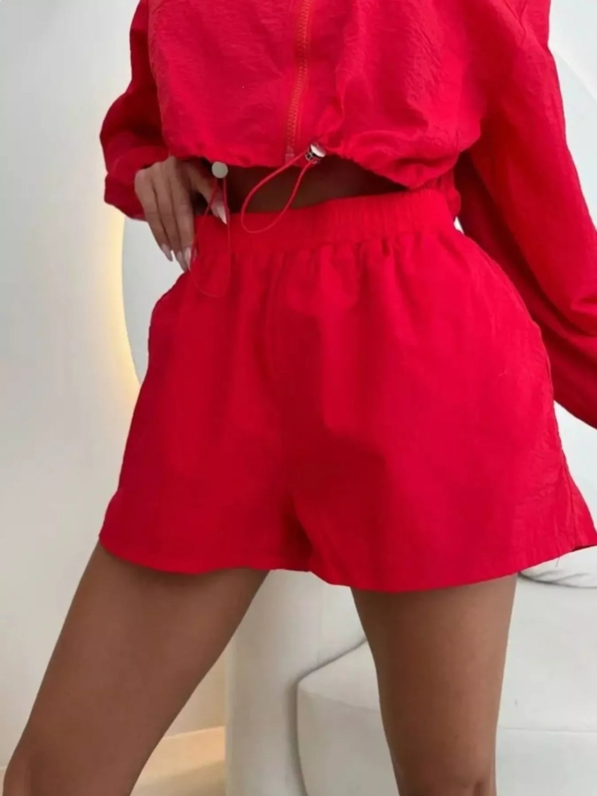 Red zip-up jacket and shorts set, close-up zipper front and drawstring waist