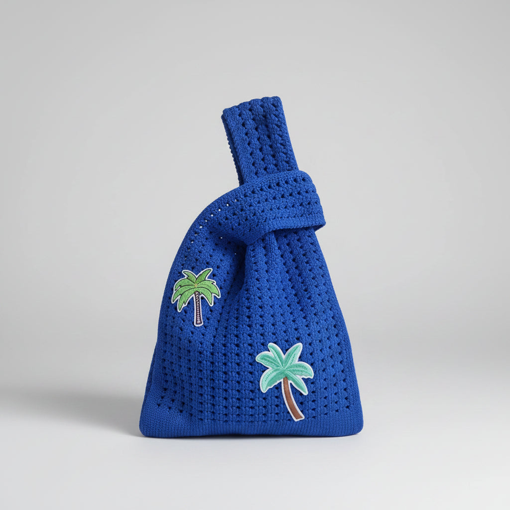 Blue crocheted knot wrist bag with green and light blue palm tree appliques