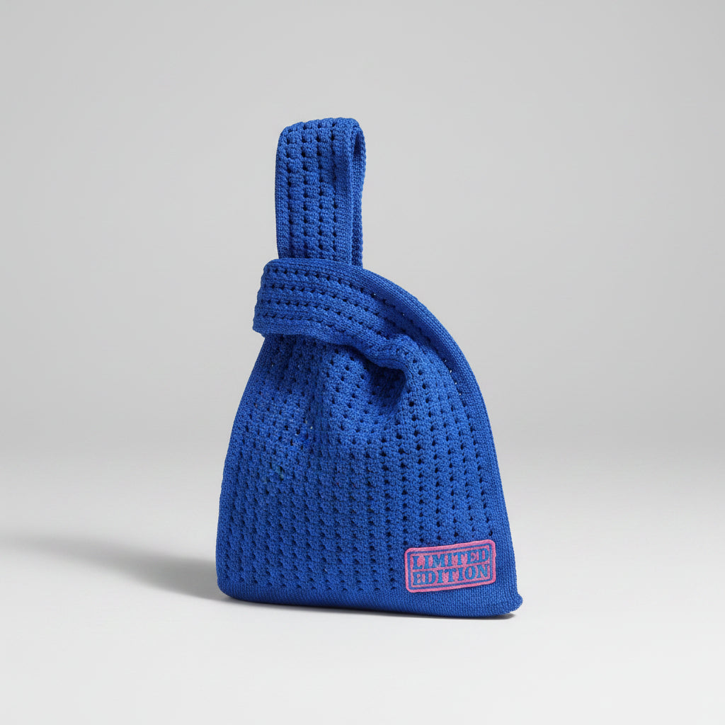 Royal blue crocheted knot wrist bag with front logo patch and fabric strap