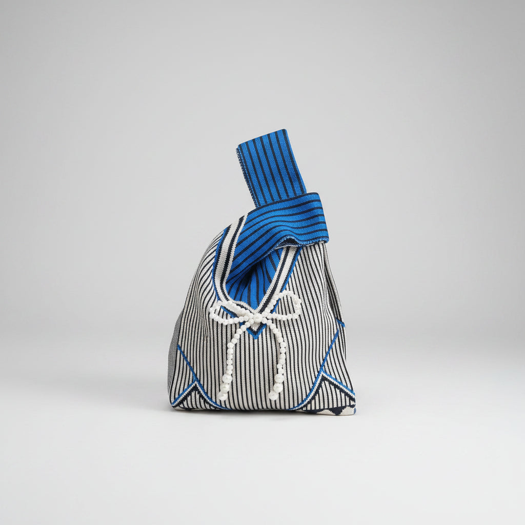 Knot wrist bag with blue-and-white stripes and braided cord bow.