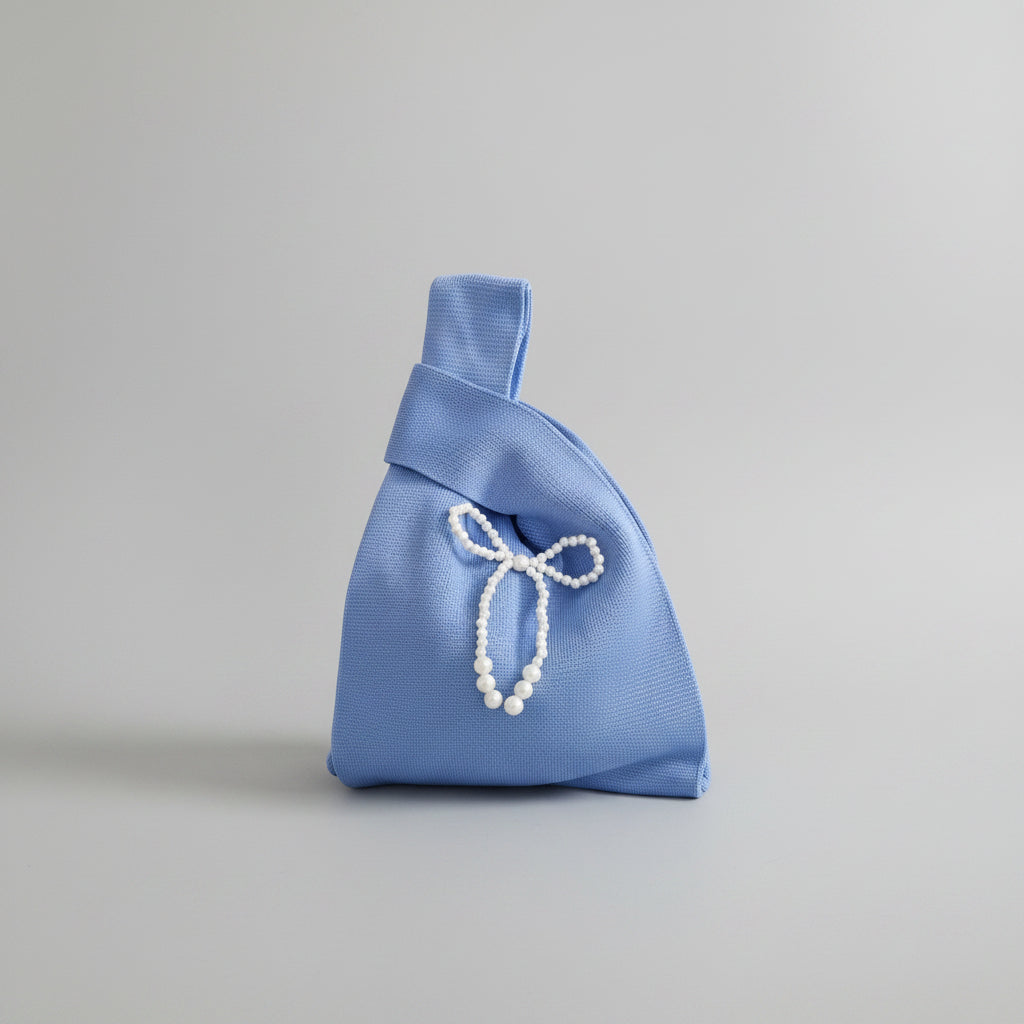 Knot wrist bag in light blue with pearl bead bow and dangling beads.