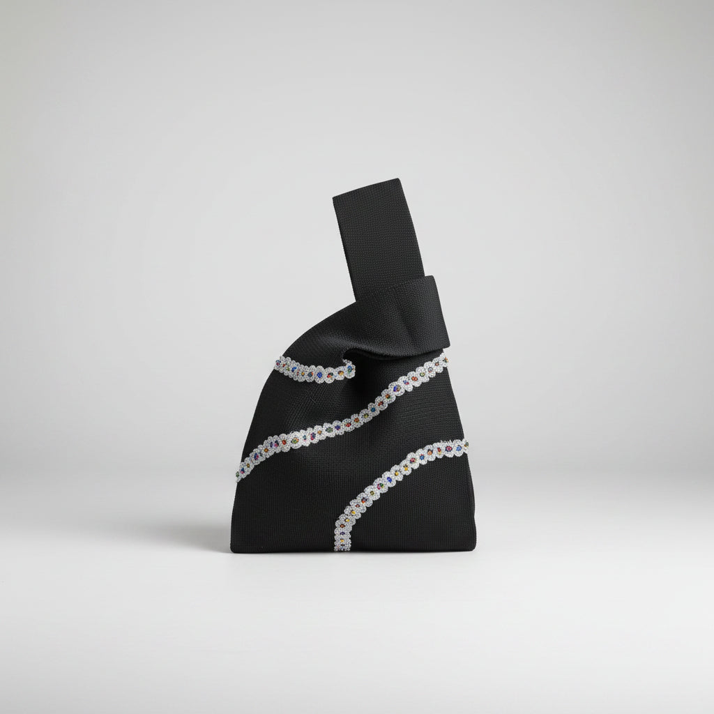 Black satin knot wrist bag with white beaded stripes and short top handle