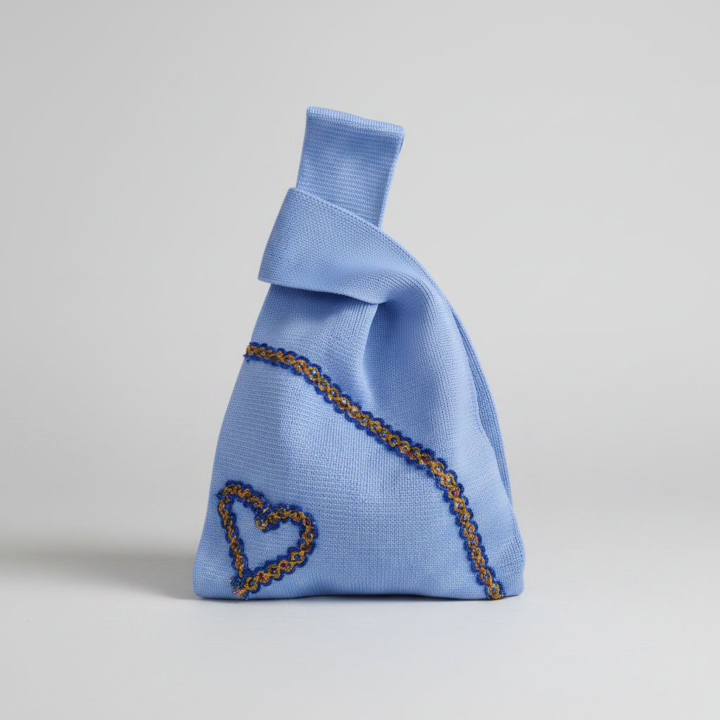 Light blue knot wrist bag with gold chain trim and heart embroidery