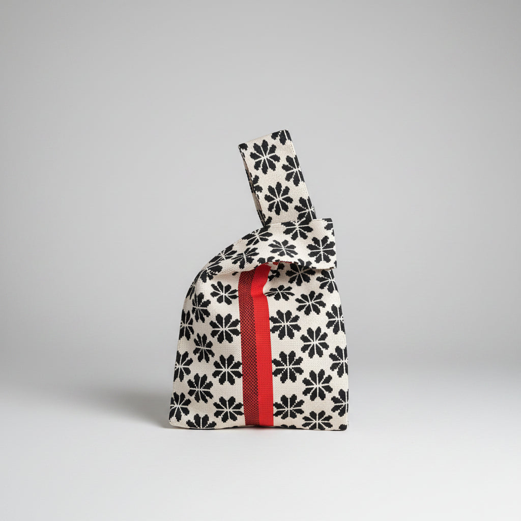 White knot wrist bag with black clover pattern and red vertical stripe
