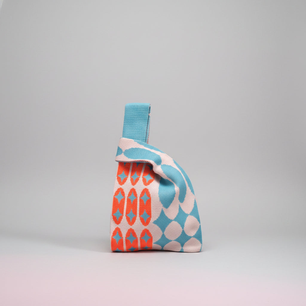 Knot wrist bag in light blue with geometric and diamond pattern