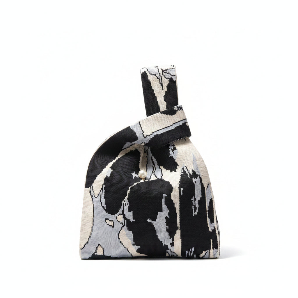 Knot wrist bag with black-and-cream animal print and beaded tie detail