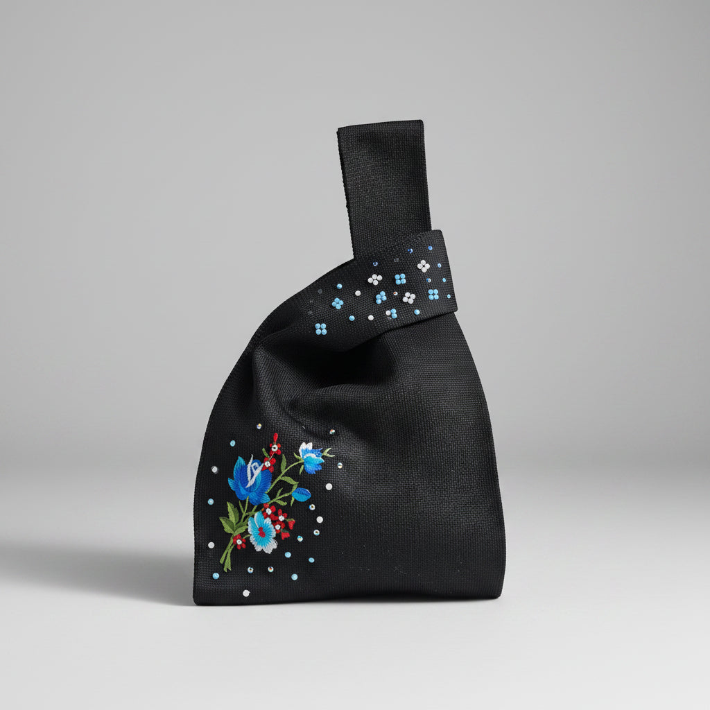 Black knot wrist bag with blue floral embroidery, jeweled dots, and fabric loop