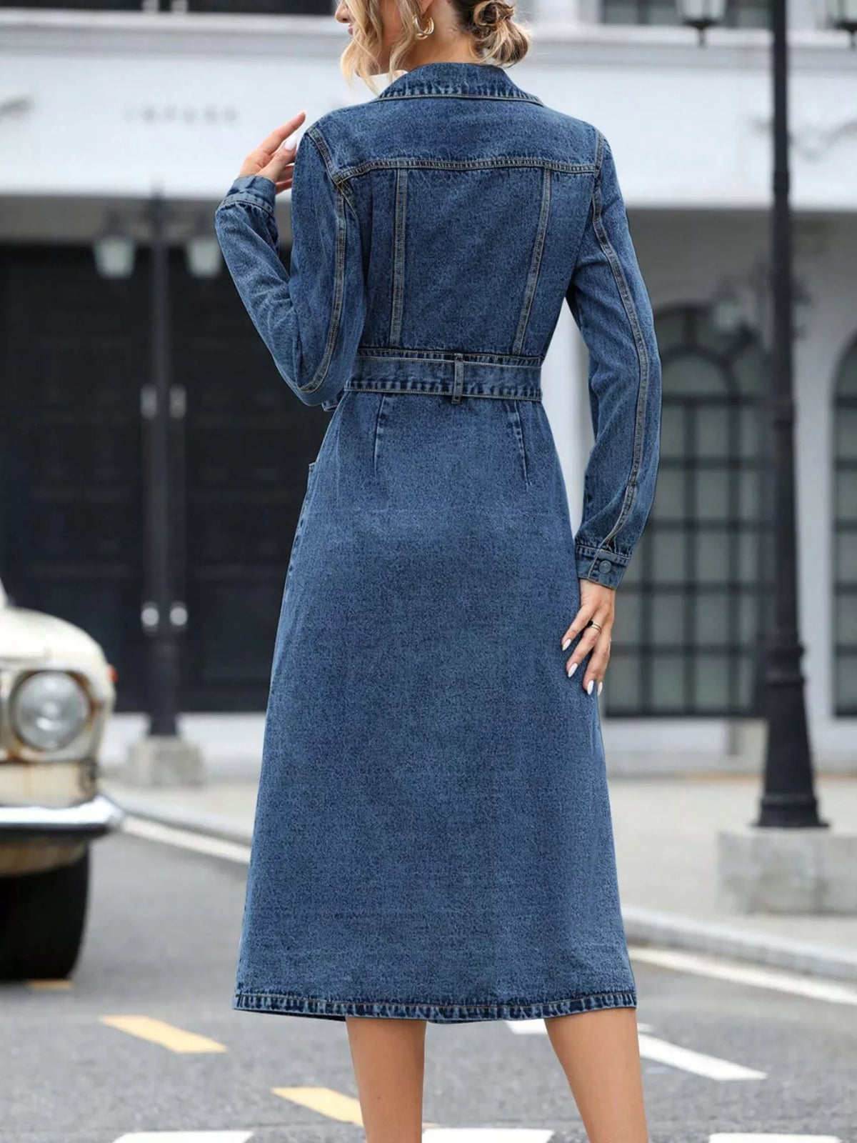 Back view of blue denim belted long-sleeve dress with yoke seams and center back.