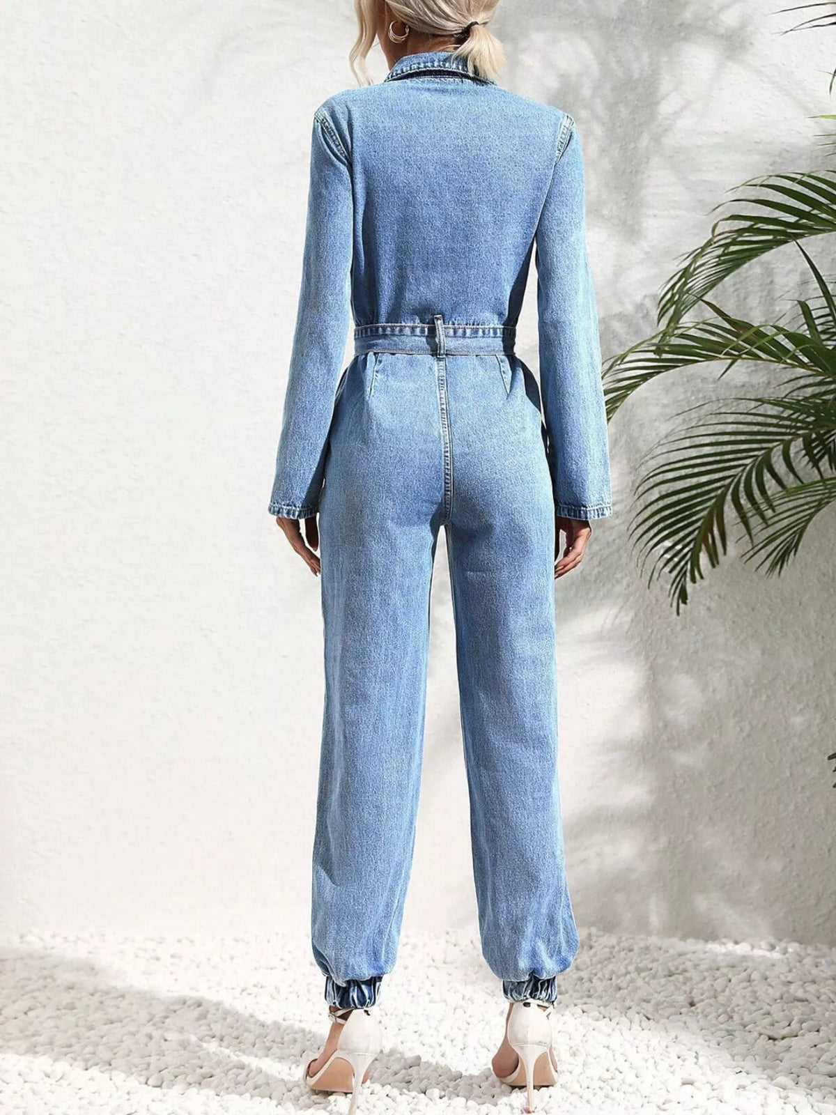 Medium blue denim button-front jumpsuit back view with waist tie belt