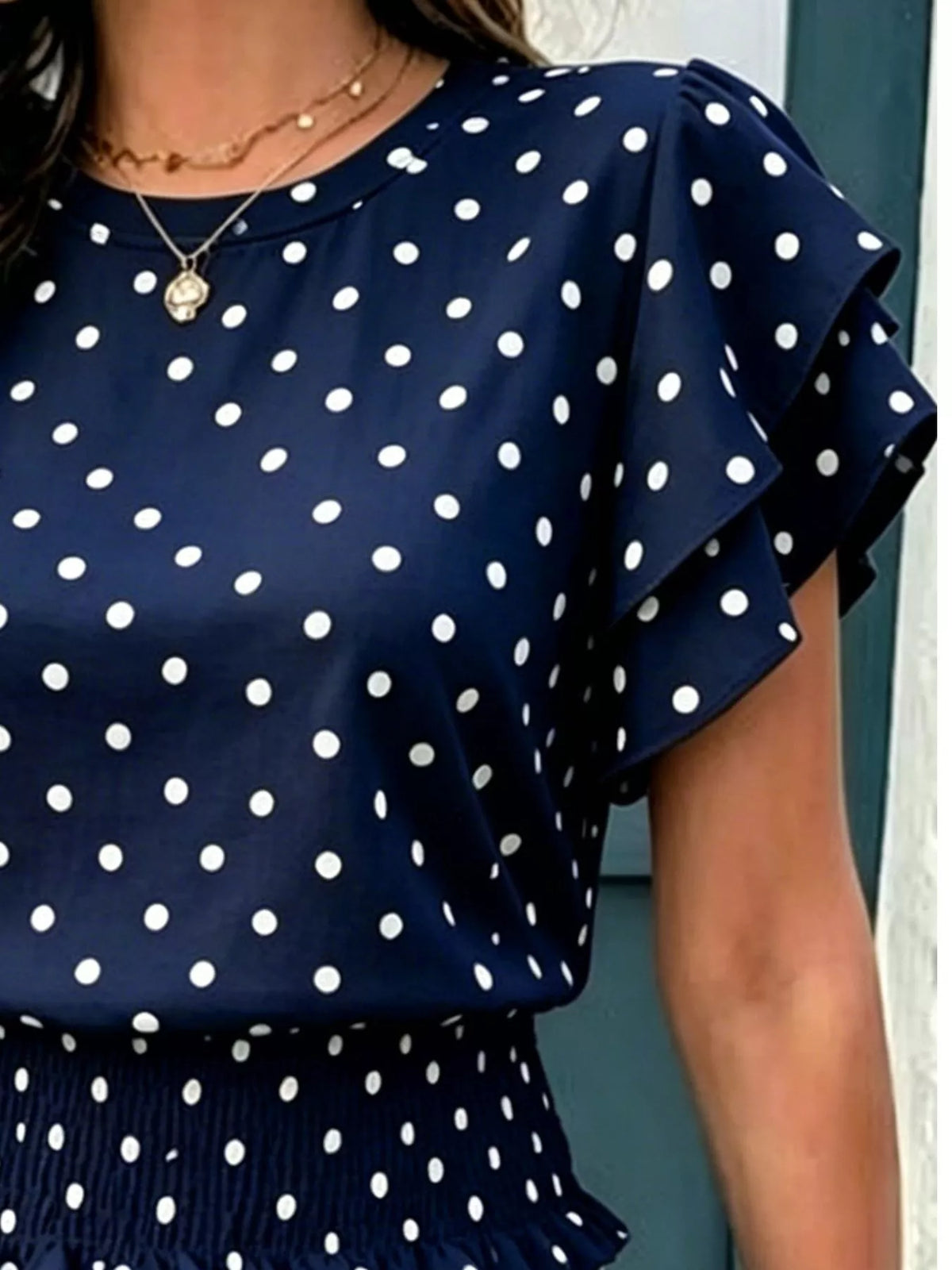 Navy polka dot blouse with puffed ruffle short sleeves and gathered waist