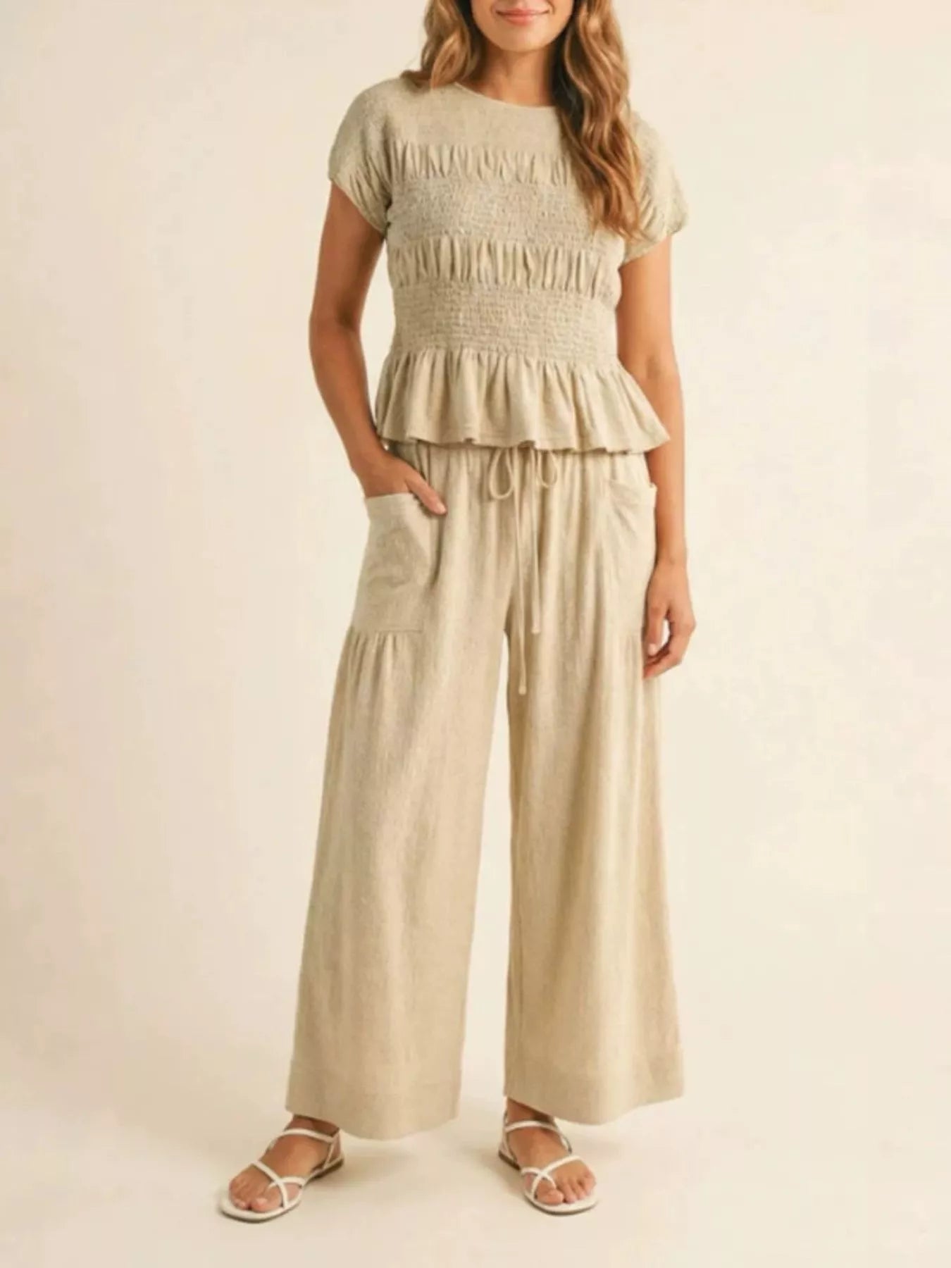 Beige smocked peplum top and wide-leg pants set with tiered ruffle hem and drawstring waist