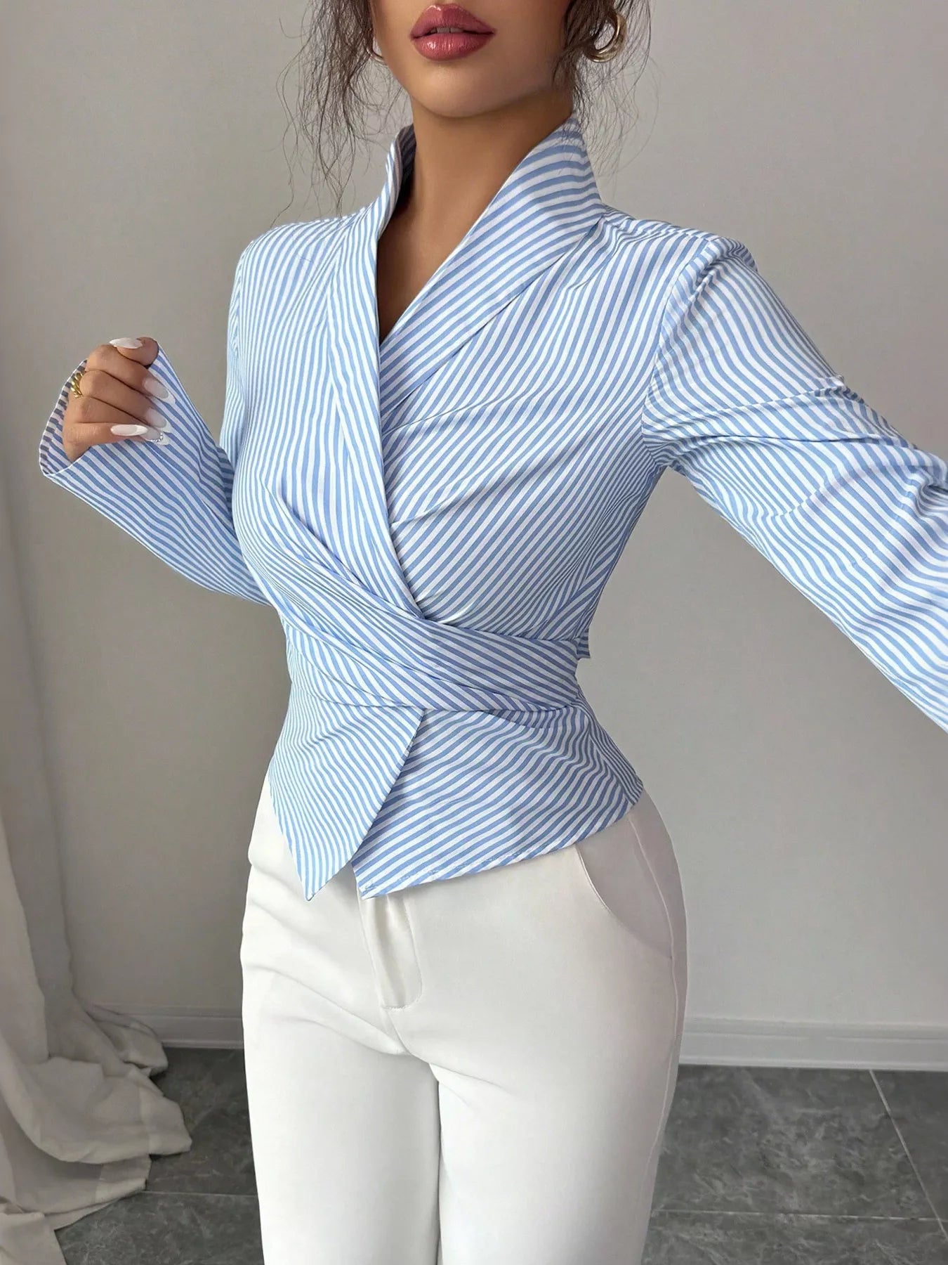 Blue striped long sleeve wrap blouse with V-neck and tied waist peplum detail