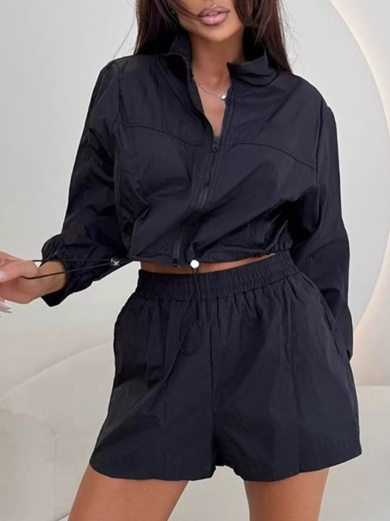 Black zip-up long sleeve jacket and elastic-waist shorts set, cropped detail