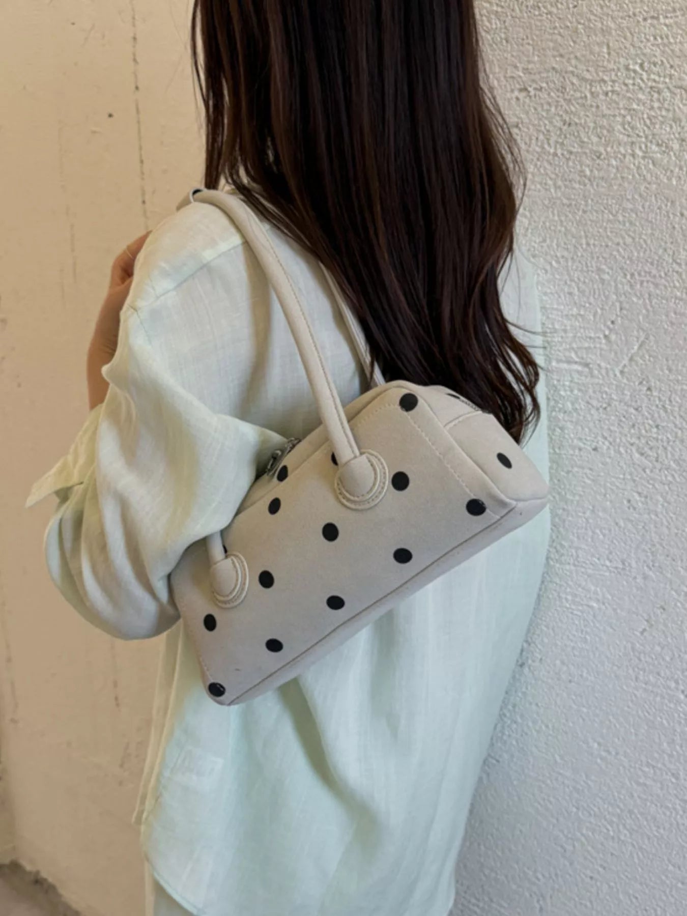 Off-white polka dot shoulder bag with rounded handles and compact rectangular shape