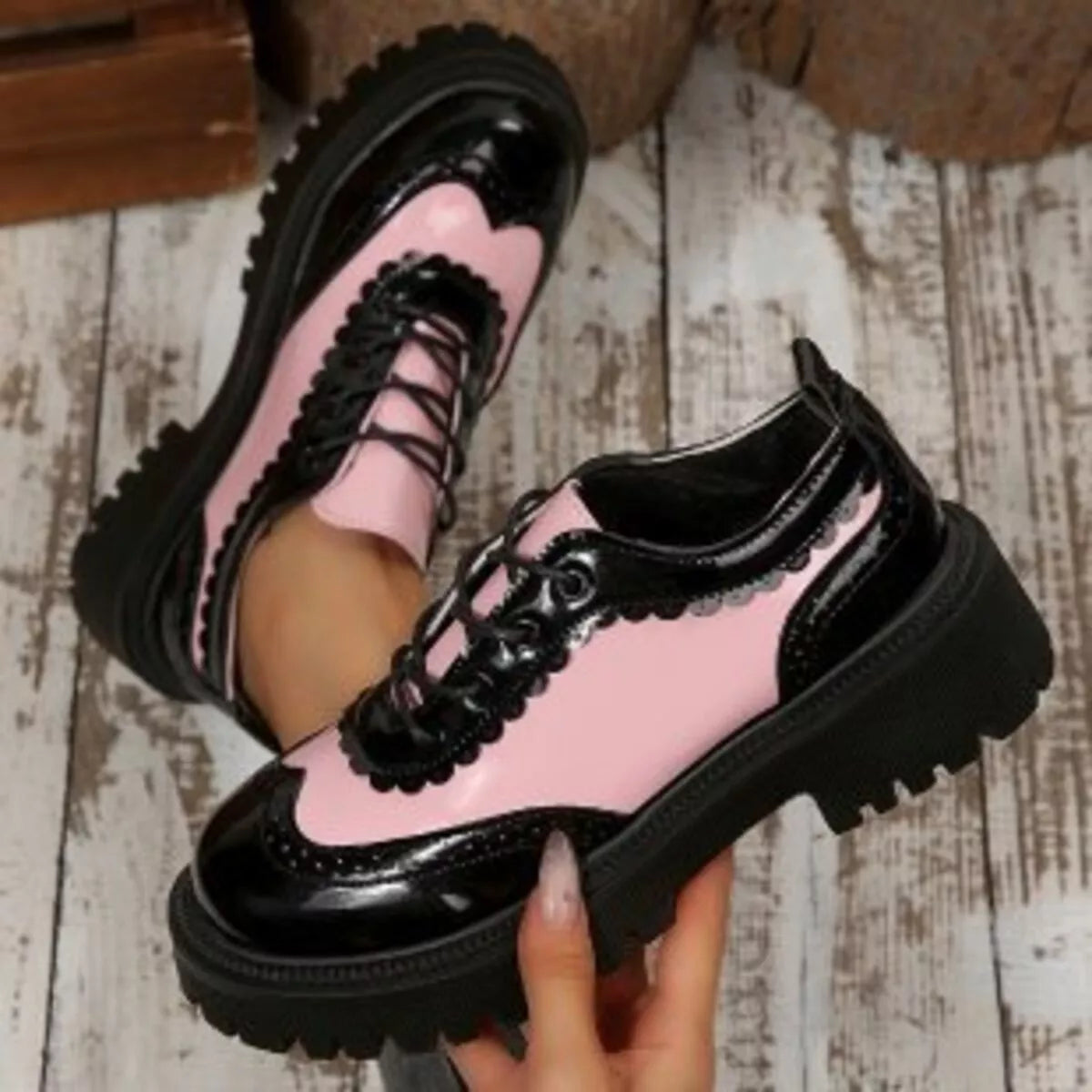 Pink-and-black platform loafers with lace-up design and glossy finish, thick sole
