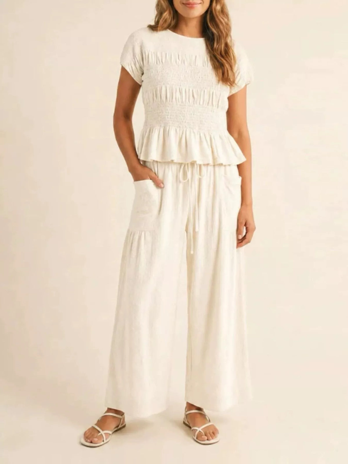 White smocked peplum top and wide-leg pants set with tiered ruffle peplum and drawstring waist