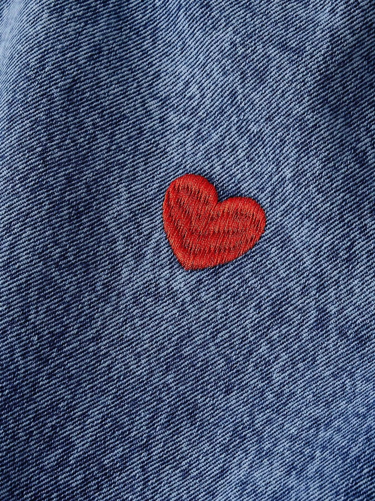 Red embroidered heart on blue denim