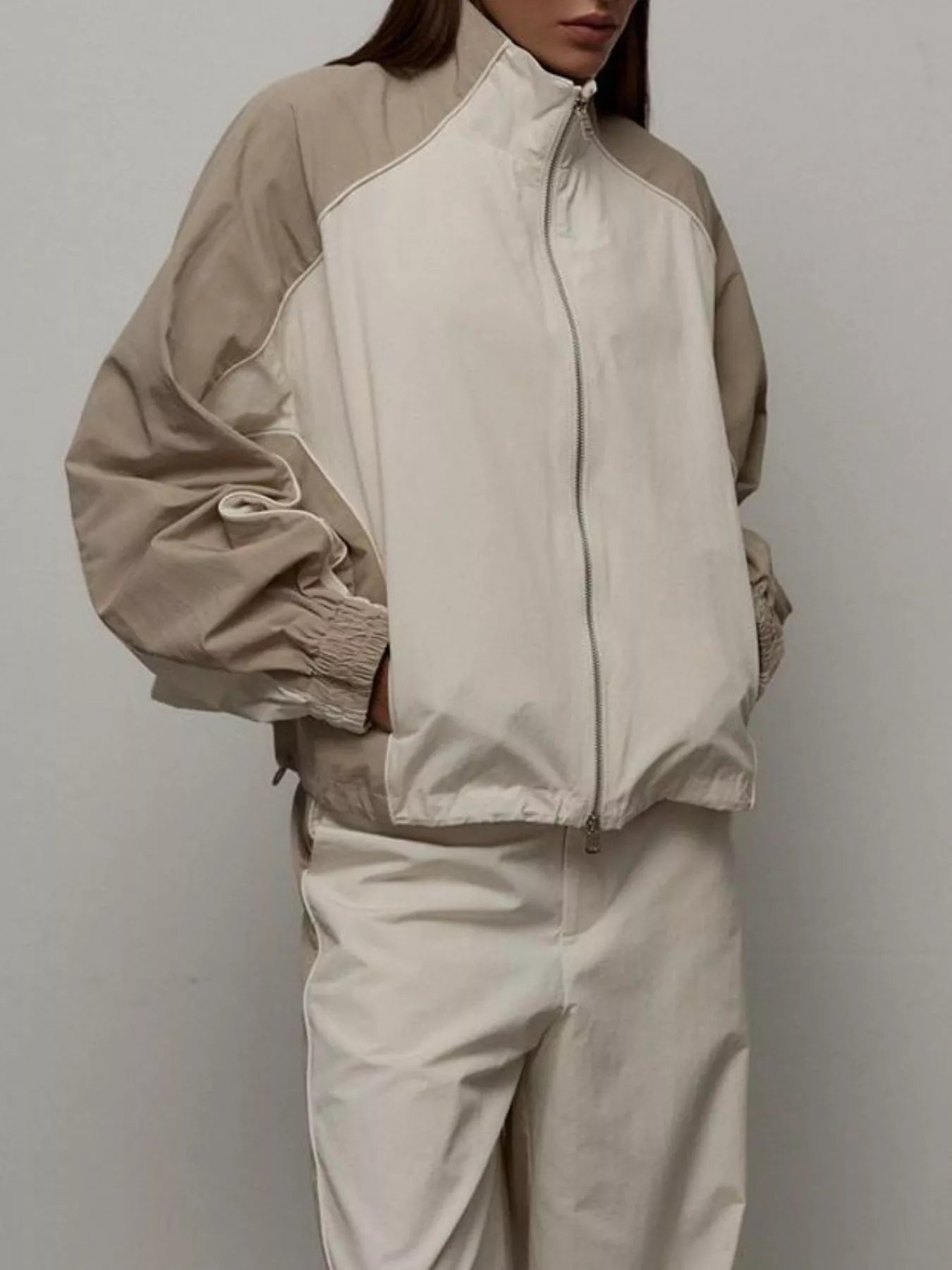Zip-up jacket and matching wide-leg pants set in light beige/cream with contrast trim.