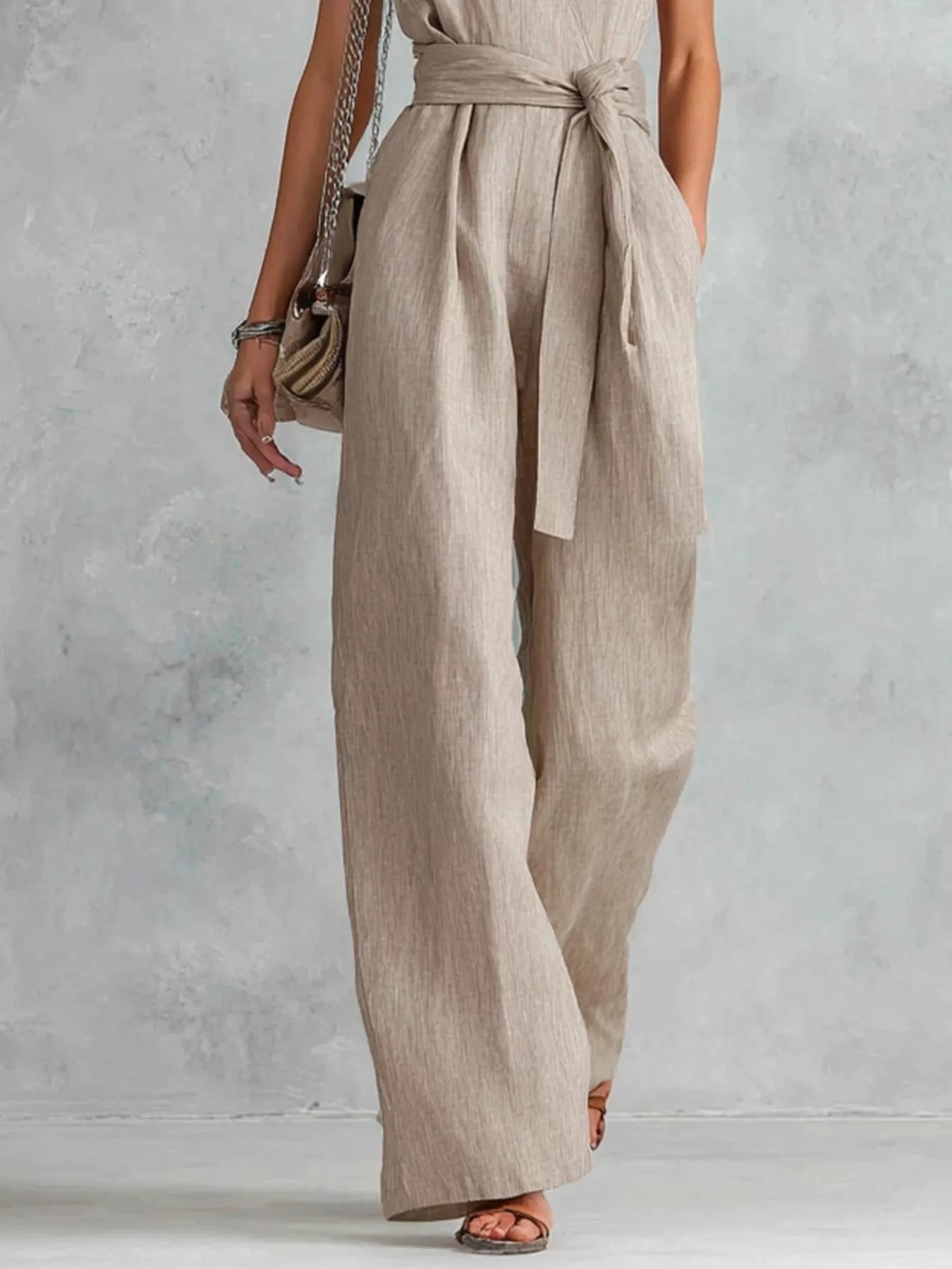 Sleeveless wide-leg jumpsuit in light beige/khaki with tied waist and flowing wide legs