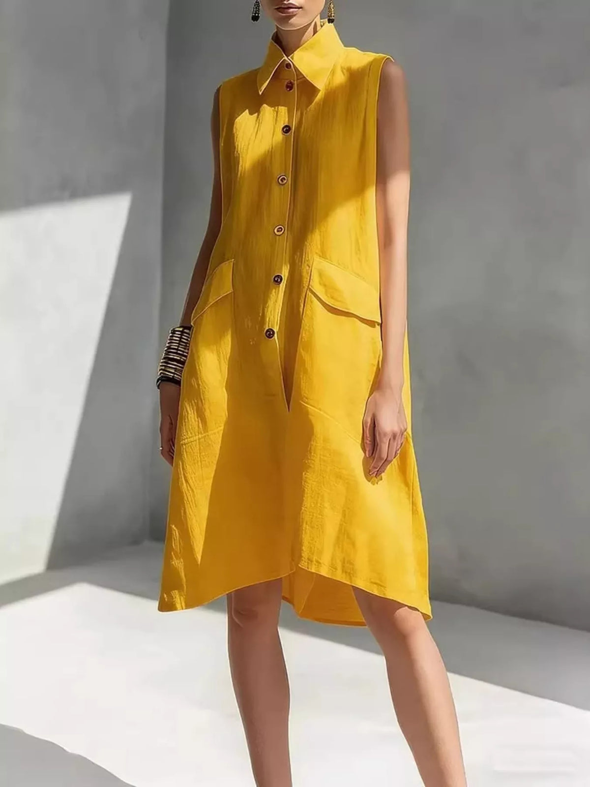 Yellow sleeveless button-front dress with pointed collar and patch pockets, knee length