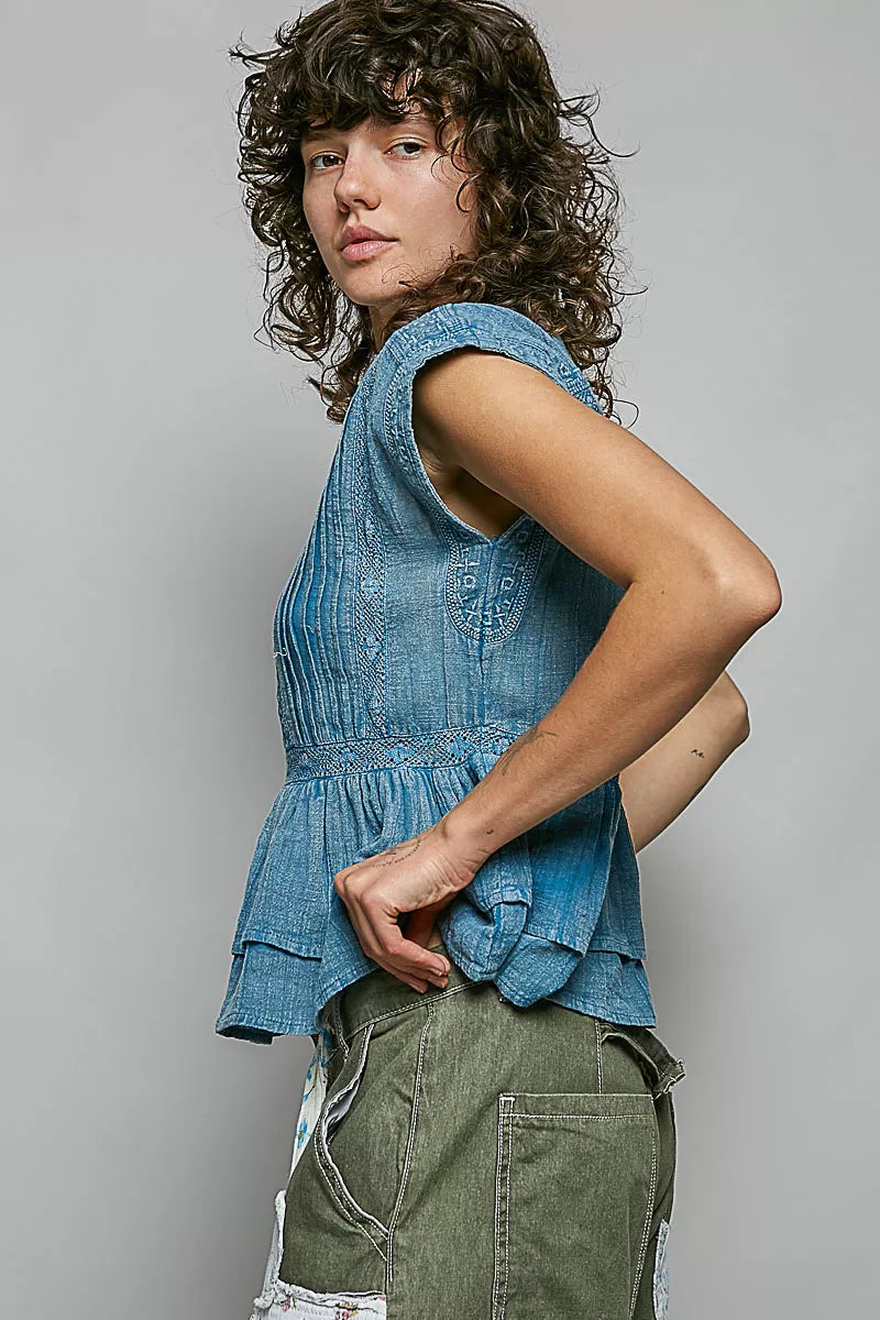 Denim blue sleeveless cotton blouse, side view, pintuck texture and button front