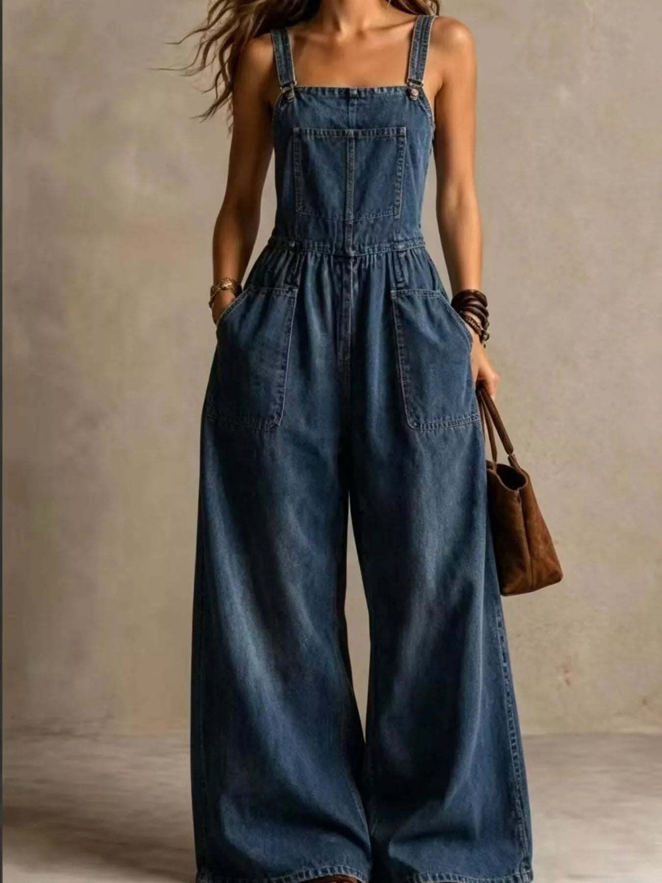 Blue denim wide-leg jumpsuit with adjustable straps and front pockets