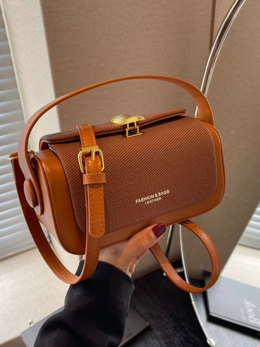 Brown flap crossbody bag with adjustable strap and gold-tone lock hardware