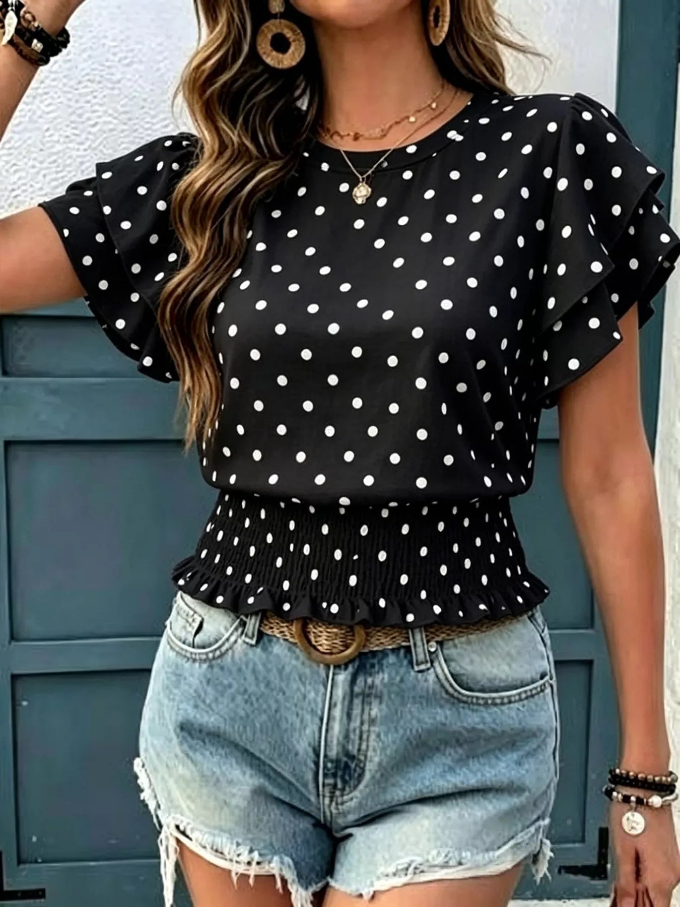Black polka dot blouse with short ruffle sleeves and peplum waist