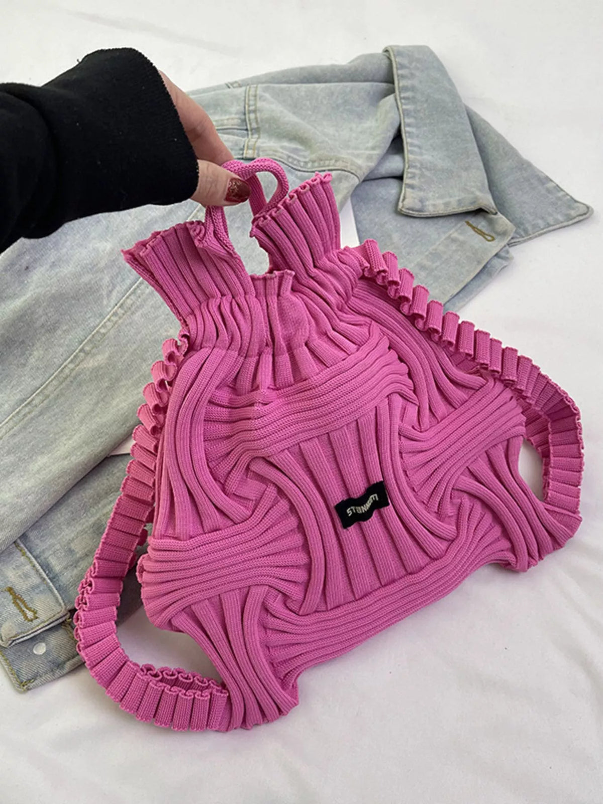 Rose red knitted backpack bag with textured knit and beaded trim, black logo patch
